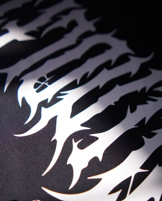 Detalhe de estampa tribal branca em tecido preto